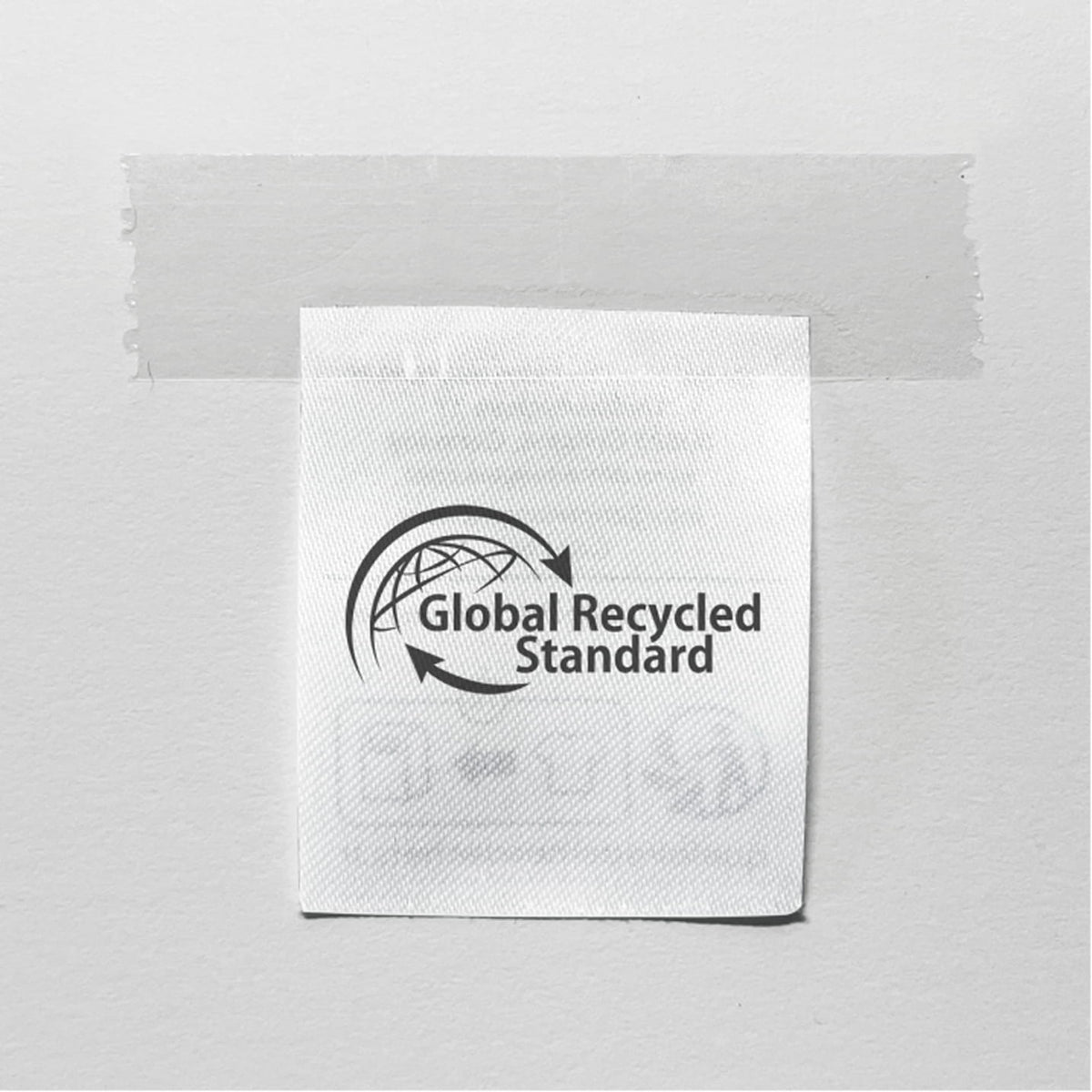 Etikett mit dem Siegel „Global Recycled Standard“ auf hellem Hintergrund.